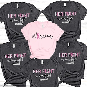 May include: Five t-shirts with a pink ribbon design and the text "HER FIGHT is our fight #TEAMNICOLE". One t-shirt is pink and has the text "Warrior" with a pink ribbon.