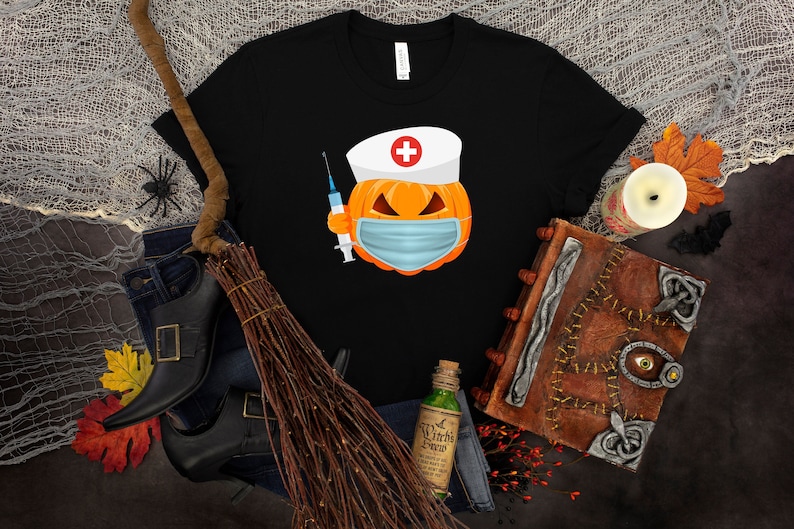 May include: Black t-shirt with a graphic of a pumpkin wearing a nurse's hat and a face mask, holding a syringe. The pumpkin has a scary expression.