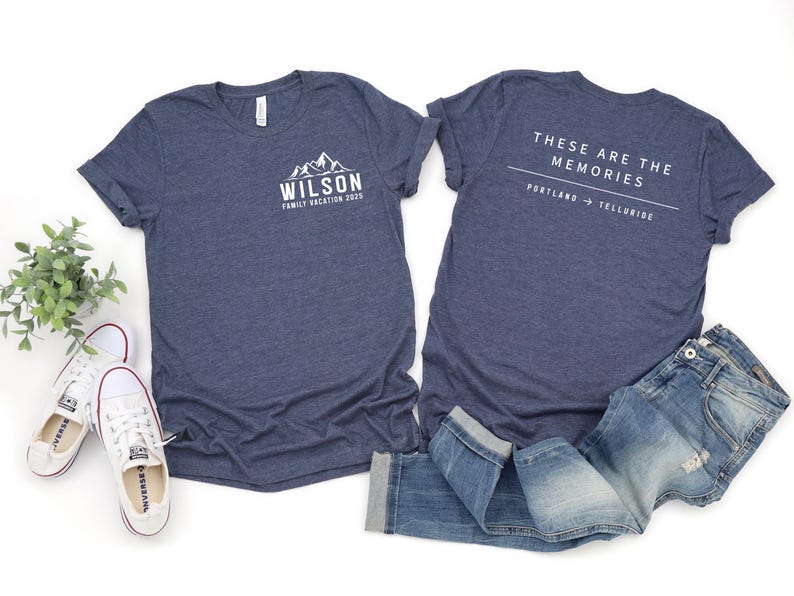Puede incluir: Dos camisetas azul marino con texto blanco y gr&aacute;ficos de monta&ntilde;as. Una camiseta dice "WILSON FAMILY VACATION 2023". La otra dice "THESE ARE THE MEMORIES PORTLAND -> TELLURIDE". Incluye vaqueros y zapatillas blancas.