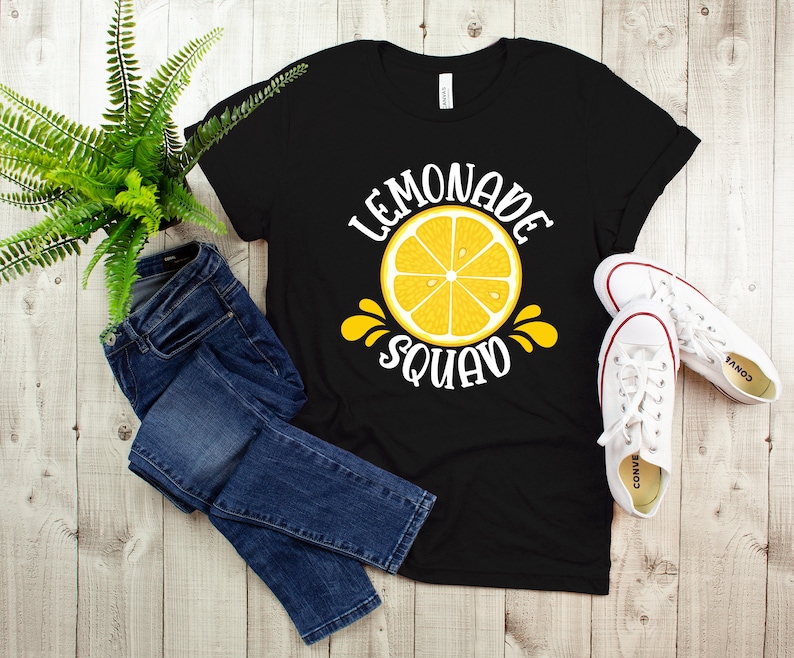 May include: Black t-shirt with a white graphic of a lemon slice and the text "Lemonade Squad".