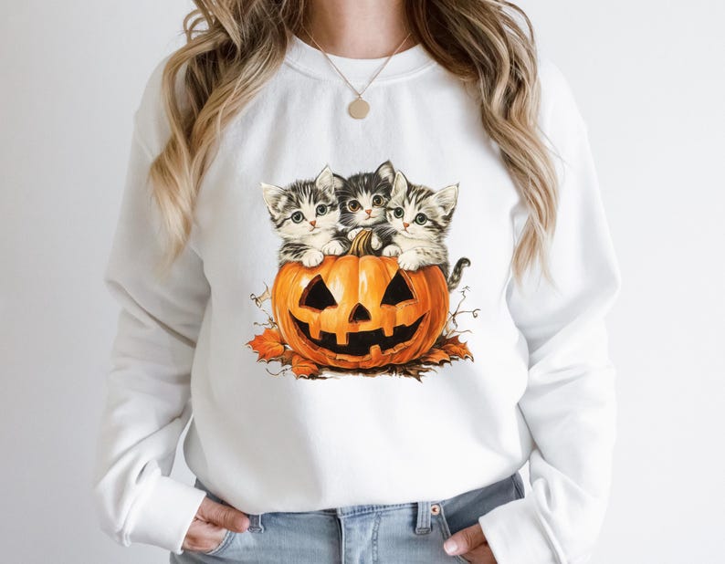 a woman wearing a white sweatshirt with kittens on it