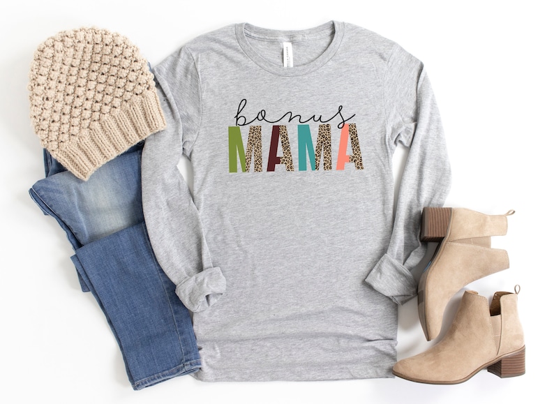 May include: Gray long-sleeve shirt with the text "bonus MAMA" in colorful letters with a leopard print pattern.