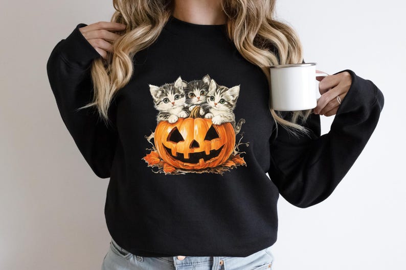 a woman holding a cup of coffee with two cats on it
