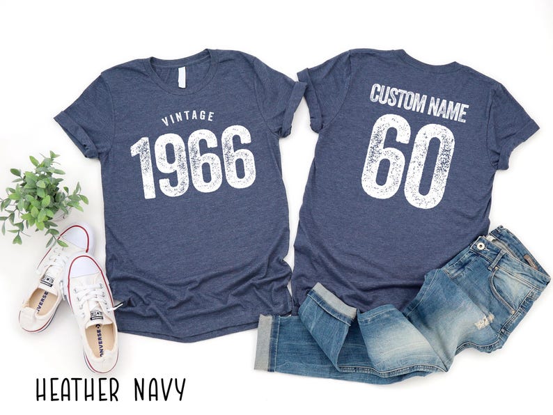 a pair of blue vintage-style t-shirts with the text "VINTAGE 1966" printed on them, along with a pair of jeans and sneakers.