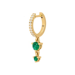 May include: Gold hoop earrings with a dangling emerald green gemstone drop. The hoop is accented with small clear stones.