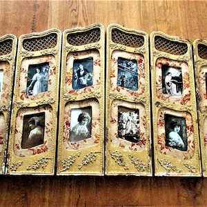May include: A gold-coloured wooden screen with eight framed black and white photographs. The screen is decorated with floral patterns and has a woven lattice design.