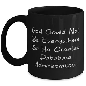 Könnte beinhalten: Schwarze Kaffeetasse mit weißem Text, der lautet: "Gott konnte nicht überall sein, also schuf er Datenbankadministratoren."