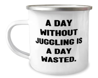 May include: White enamel mug with a silver rim. The mug has black text that reads "A day without juggling is a day wasted."