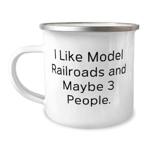 May include: White enamel mug with a silver rim. The mug has black text that reads "I Like Model Railroads and Maybe 3 People."