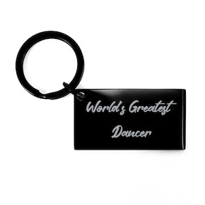 May include: Black metal keychain with a rectangular tag that reads "World's Greatest Dancer" in a silver cursive font.
