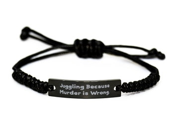 May include: Black adjustable bracelet with a black metal tag that reads "Juggling Because Murder is Wrong."