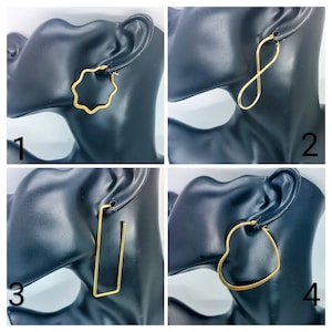 Peut inclure: Quatre boucles d'oreilles en or de formes différentes. La première boucle d'oreille est en forme de fleur, la deuxième est un symbole d'infini, la troisième est un rectangle et la quatrième est en forme de cœur.