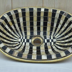 Brass sink created with unlacquered brass, bone and a resin finish