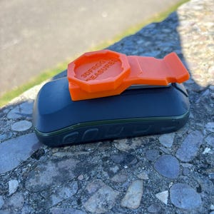 Peut inclure: Clip orange imprimé en 3D avec le texte "3DFROG TREASURE" sur un appareil noir et vert.