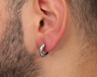 May include: A silver hoop earring with a woven design.