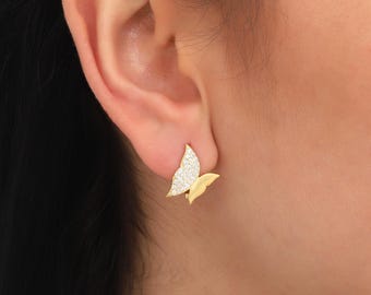 May include: A pair of gold butterfly earrings with clear cubic zirconia stones.