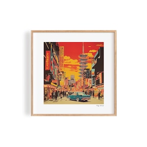 Könnte beinhalten: Eine gerahmte Illustration einer Straßenszene in Tokio, Japan. Die Illustration zeigt ein blaues Auto, das eine Straße entlangfährt, die von Gebäuden und Menschen gesäumt ist. Der Himmel ist in leuchtendem Orange und Gelb gehalten, und die Gebäude sind in einer Mischung aus Rot, Gelb und Blau gehalten. Der Text "大名売出し" ist auf einem der Gebäude zu sehen.