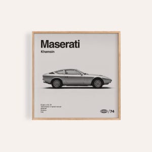 Puede incluir: Impresión enmarcada de un Maserati Khamsin plateado. El coche se muestra de perfil sobre un fondo claro. El logotipo de Maserati y el nombre del modelo están en la parte superior, con detalles técnicos y el año 1974 en la parte inferior.