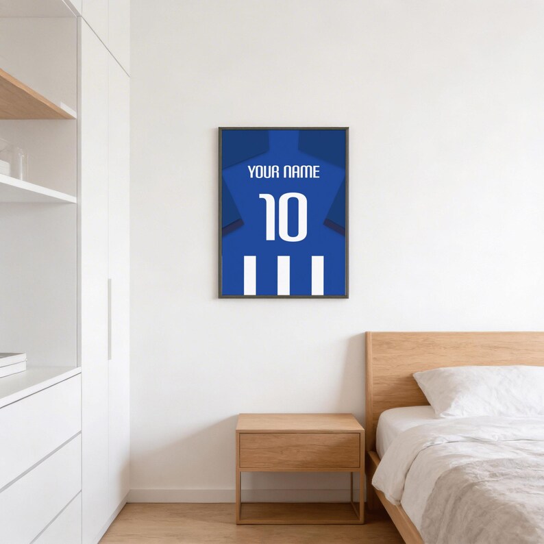 a bedroom with a bed, a nightstand, and a framed poster of a blue soccer jersey with the number 10 hanging on the wall.