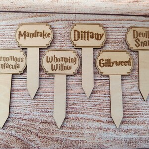 May include: Six wooden plant markers with different Harry Potter plant names: Mandrake, Dittany, Devil's Snare, Venomous Tentacula, Whomping Willow, and Gillyweed.