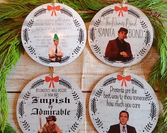 May include: Four round Christmas ornaments with quotes and images from a TV show. Each ornament has a red bow and twine for hanging. The ornaments feature quotes like "The Names Bond, Santa Bond" and "Impish or Admirable."