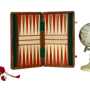 May include: A wooden backgammon game set with a green felt lining, a red velvet bag, and a small globe with a gold stand.