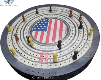 May include: A wooden circular game board with a red, white, and blue American flag design in the center. The board has a track with numbered spaces and a "Start" and "Finish" area. The board is decorated with black and yellow game pieces.
