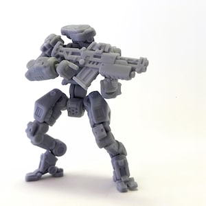 Könnte beinhalten: Eine graue, bewegliche Roboterfigur in Kampfhaltung, die ein Gewehr hält. Die Figur hat detaillierte mechanische Komponenten, darunter Gelenke, Panzerplatten und ein Kopfstück. Der Roboter steht vor einem weißen Hintergrund.