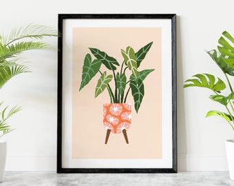 May include: A framed print of a stylized illustration of a green plant in a pink and white patterned pot with wooden legs on a peach background.