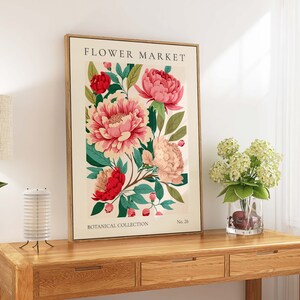 Pu&ograve; includere: Una stampa botanica incorniciata con fiori rosa e rossi con foglie verdi. La stampa ha il testo "FLOWER MARKET" in alto e "BOTANICAL COLLECTION" in basso. Il numero "No. 26" &egrave; nell'angolo in basso a destra.