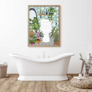 May include: A framed print of a bathroom with a toilet, plants, and a tiled floor. The print has a light blue background with white flowers and a wooden frame.