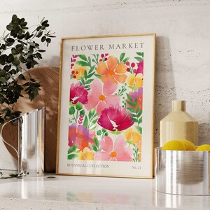 May include: A framed watercolor print of a floral pattern with pink, yellow, and orange flowers. The print is titled "FLOWER MARKET" and has the text "BOTANICAL COLLECTION" and "No. 21" at the bottom.