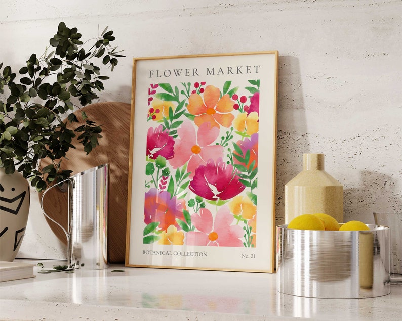 May include: A framed watercolor print of a floral pattern with pink, yellow, and orange flowers. The print is titled "FLOWER MARKET" and has the text "BOTANICAL COLLECTION" and "No. 21" at the bottom.