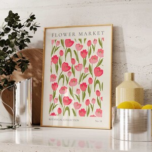 May include: A framed print featuring a white background with a repeating pattern of pink tulips with green stems and leaves. The print is titled "FLOWER MARKET" at the top, "BOTANICAL COLLECTION" at the bottom left, and "No. 14" at the bottom right.
