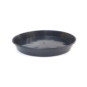May include: A black plastic saucer for a plant pot. The saucer is round and has a slightly raised edge.