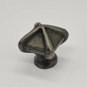 May include: A silver metal cabinet knob with a geometric design. The knob has a square base and a pointed top.