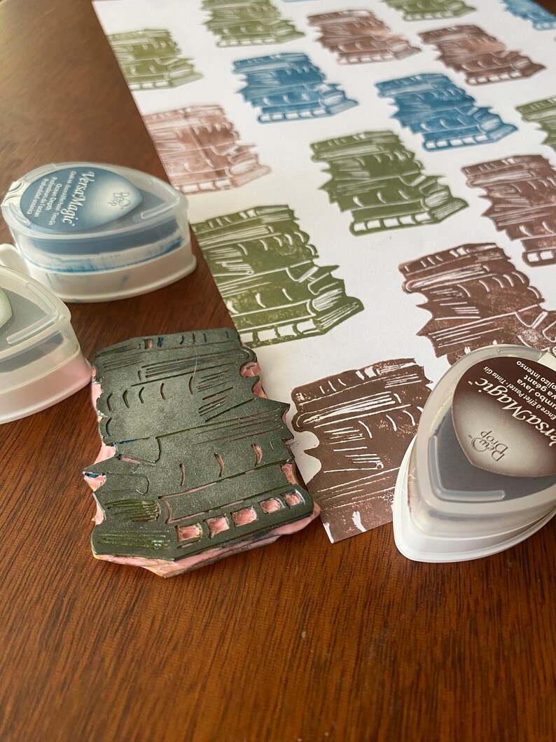 Stack of books with ink pads used for repeating pattern.