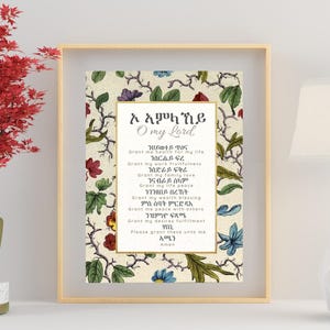 Pode incluir: Uma impress&atilde;o emoldurada com elementos florais e bot&acirc;nicos, com texto em uma fonte de script. A impress&atilde;o est&aacute; em uma moldura dourada, e uma pequena &aacute;rvore vermelha em um vaso dourado est&aacute; &agrave; esquerda. Uma l&acirc;mpada branca com base dourada est&aacute; &agrave; direita.