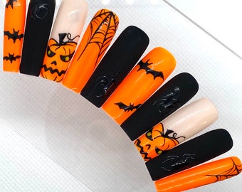 Op de afbeelding: Set van tien Halloween-thema nagelwraps met oranje en zwarte ontwerpen. De ontwerpen omvatten pompoenen, vleermuizen en spinnenwebben.