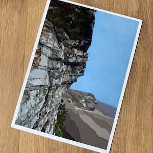 May include: A digital illustration of a rocky cliff face with a view of a valley below. The sky is blue and the cliff is a light gray with some dark gray shadows.