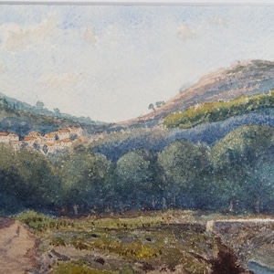 May include: A watercolor painting depicting a village nestled in a valley, with a stone bridge in the foreground and a hill in the background. The sky is a light blue with white clouds.
