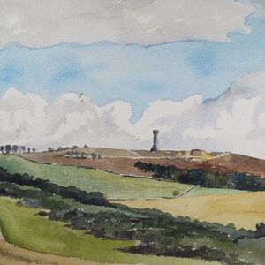 May include: A watercolor painting of a landscape with a tall tower on a hill in the distance. The sky is blue with white clouds. The foreground is a field of green grass with a dirt road leading to the hill.