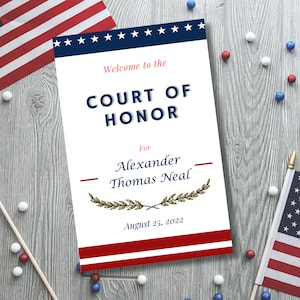 May include: A white card with blue and red stripes and stars at the top. The text on the card reads "Welcome to the Court of Honor for Alexander Thomas Neal August 25, 2022".