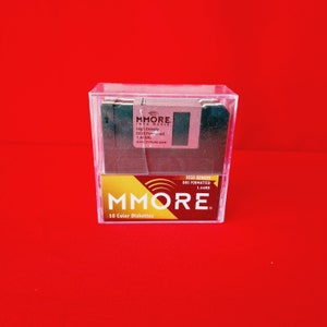 May include: A pack of 10 high-density, colour diskettes, formatted for DOS. The diskettes are in a clear plastic case with a yellow label that reads "MMORE. 10 Colour Diskettes". The label also includes the text "High Density DOS Formatted 1.44MB".