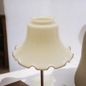 Vintage cream colored glass lampshade with brown rufgle edge.