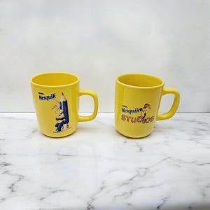 2 Nesquik Nestlé studios pencil mugs.