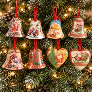 Puede incluir: Un conjunto de ocho adornos colgantes que incluye seis formas de campana y dos de corazón. Cada pieza muestra coloridas ilustraciones de estilo vintage con motivos de Santa Claus, trineos y escenas festivas, suspendidas por cintas rojas.
