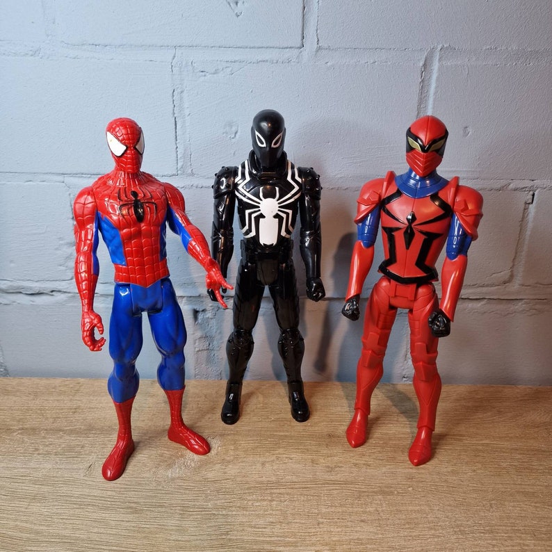 Pu&ograve; includere: Tre action figure di personaggi di Spider-Man. Una &egrave; rossa e blu, una &egrave; nera e bianca e una &egrave; rossa con accenti neri.