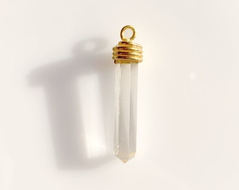 May include: A clear quartz crystal point pendant with a gold-toned metal cap. The pendant is perfect for adding a touch of elegance to any jewelry project.