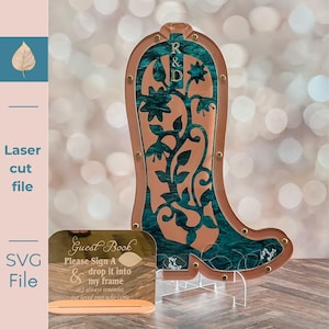 Puede incluir: Un marco decorativo en forma de bota cortado con láser con un diseño floral turquesa y las iniciales "R & D". Incluye un pequeño libro de visitas con texto. El marco está hecho de madera y acrílico.